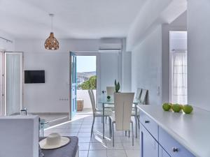 a white kitchen with a table and a dining room at Ifestos home with private veranda, Paros in Logaras