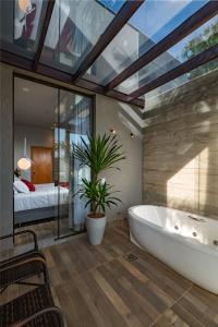 uma casa de banho com uma banheira e um quarto com uma cama em POUSADA DO SANTO em Igarapé
