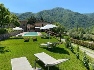 a yard with a pool and tables and chairs at Agriturismo I Chiosi in Comano