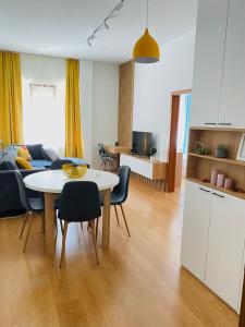 a kitchen and a living room with a table and chairs at Уютен апартамент в сърцето на прекрасен град Варна in Varna City