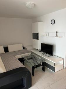 - une chambre avec un lit et un bureau avec une télévision dans l'établissement Apartmani Marina, à Crikvenica