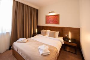 A bed or beds in a room at Hotel Sun Loznica