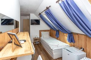 mały pokój z niebieskimi zasłonami i łóżkiem w obiekcie Cseppkő Panzió w mieście Abaliget