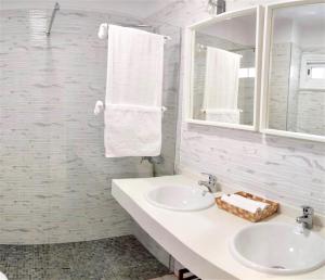 een badkamer met 2 wastafels, een spiegel en handdoeken bij GOLD SAND, Huge Terrace, Fast Wi-Fi, Sat TV in San Miguel de Abona