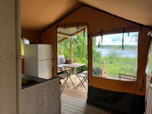 an inside of a tent with a refrigerator and a table at 'Glamping' Angelzelt am See mit Steg und Boot (Mecklenburger Seenplatte) in Blankensee