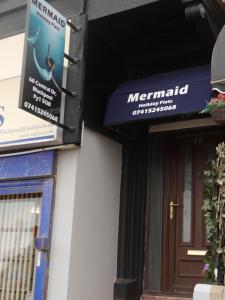 a sign on the side of a building with a mermaid sign at Mermaid Holiday Flats in Blackpool