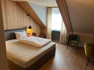 a bedroom with a bed and a chair and a window at Das kleine Landhotel in Dorsten