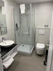 a bathroom with a shower and a toilet and a sink at Das kleine Landhotel in Dorsten