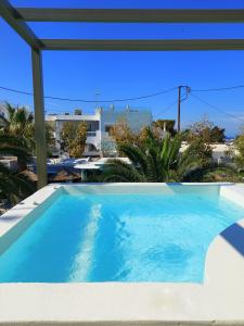 a large swimming pool with a view of a building at Zephyros Hotel in Kamari