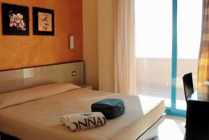 a bedroom with a bed with a suitcase on it at Grand Hotel La Tonnara in Amantea