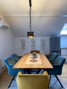 a dining room with a wooden table and blue chairs at Megy in Vinkovci