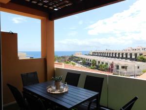 a table on a balcony with a view of the ocean at Ocean Sun & Golf II in San Miguel de Abona