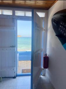 an open door with a view of the ocean at Erginas Boat House in Plaka Milou