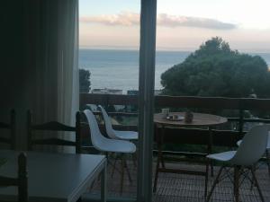 balcón con mesa, sillas y vistas al océano en Canyelles Apartament, en Roses