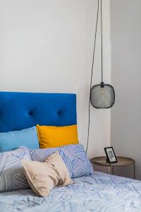a bed with a blue and yellow headboard in a bedroom at La Maison in Anobra