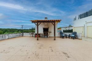 a patio with a gazebo and a fireplace on a roof at La Maison in Anobra