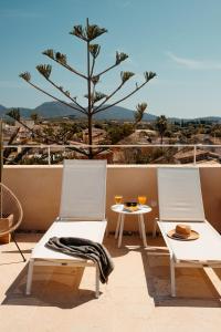 two chairs and a table on a balcony with a tree at Hotel Boutique Can Pocovi in Sant Llorenç des Cardassar +160 photos