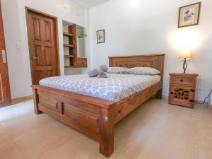 a bedroom with a wooden bed and a wooden door at Camali Hotel in Santa Marta
