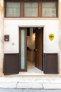 een open deur van een gebouw met een bord erop bij Civico93Loft in Terlizzi