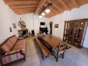 un soggiorno con tavolo in legno e divano di Il Casale di Lucullo a Lucignano
