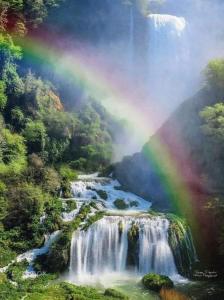 einen Regenbogen über einem Fluss mit einem Wasserfall in der Unterkunft Casa Vacanze Le Cascate in Le Marmore