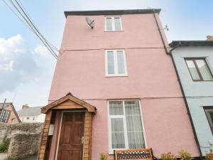 a pink building with a clock on top of it at The Old Lighthouse Cottage in Watchet