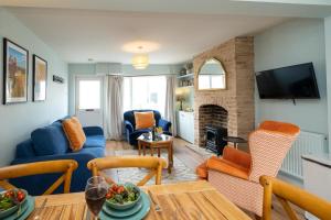 a living room with a blue couch and a fireplace at Quay Cottage - Aldeburgh Coastal Cottages in Aldeburgh