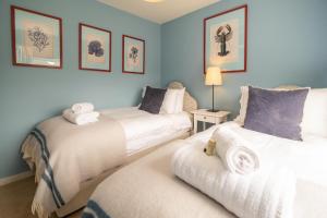 two beds in a room with blue walls at Quay Cottage - Aldeburgh Coastal Cottages in Aldeburgh