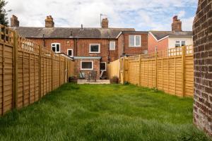 a wooden fence in the yard of a house at Quay Cottage - Aldeburgh Coastal Cottages in Aldeburgh