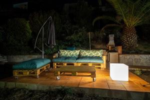 a couch and a coffee table on a patio at night at CALA 51 - Villa with sea view in Blanes