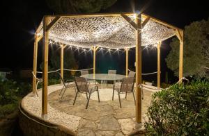 a table and chairs under a gazebo at night at CALA 51 - Villa with sea view in Blanes