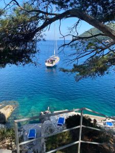 a sailboat in the water with a boat in the ocean at Stermasi Apartments in Saplunara