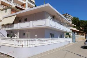 ein weißes Haus mit Balkon auf einer Straße in der Unterkunft Kosta Apartments in Sarandë