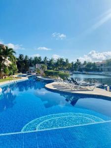 una gran piscina con sillas y agua en Waterfront 3 Bedroom Spacious Condo, en Playa del Carmen