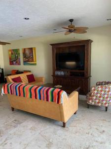 sala de estar con sofá y TV en Waterfront 3 Bedroom Spacious Condo, en Playa del Carmen