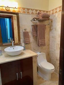 y baño con lavabo, aseo y espejo. en Waterfront 3 Bedroom Spacious Condo, en Playa del Carmen