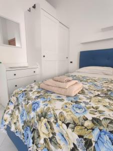 a bedroom with a bed with a floral bedspread at Casa Vacanze Da Serena in Lacco Ameno