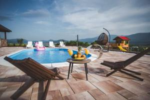 a pool with two chairs and a table with fruit on it at Villa Vanesa Bihać in Bihać