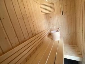 a wooden sauna with a bucket in it at Penthouse l'Ourse Bleue - Sauna privatif - accès direct aux pistes in Courchevel