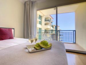 a plate of fruit and wine glasses on a bed at Vila Formosa Top View by LovelyStay in Funchal +32 photos