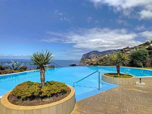 a large swimming pool with a view of the ocean at Vila Formosa Top View by LovelyStay in Funchal