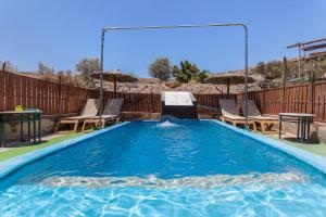 a pool with chairs and a table and a swimming pool at Edén Ecologico en Casa La Fuentita in El Charco