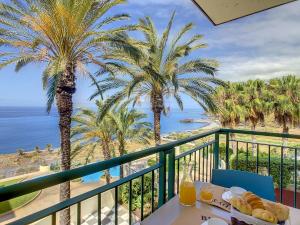 a balcony with a table and palm trees and the ocean at Vila Formosa Top View by LovelyStay in Funchal