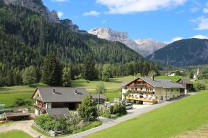 a house in a field with mountains in the background at Mösslhof App Garten in San Vito