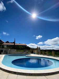 uma grande piscina com o sol no céu em Chalé Charmoso em Bananeiras no condomínio exclusivo Serra Nevada em Bananeiras