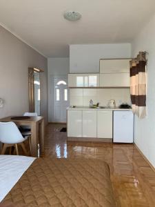 a large kitchen with white cabinets and a table at Sunrise Apartments and Studios in Star Dojran