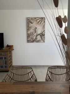 Casa Bamboo Tavira في تافيرا: كرسيين وطاولة مع لوحة على الحائط