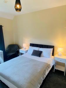 a bedroom with a large bed with two night stands at Mirfield Monastery B&B in Mirfield