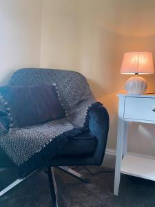 a couch sitting next to a table with a lamp at Mirfield Monastery B&B in Mirfield