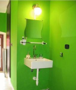 a green bathroom with a sink and a mirror at B&B Piazza Vittorio in Turin